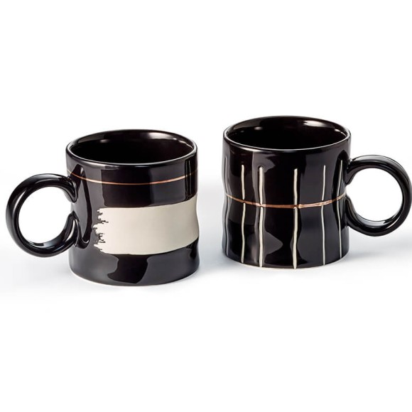 Koro: coppia di tazze in ceramica da 0,3 litri, con finitura lucida nera, dettagli bianchi opachi e accenti dorati. Superficie ondulata per un tocco unico e piacevole. Eleganza senza tempo per ogni occasione.