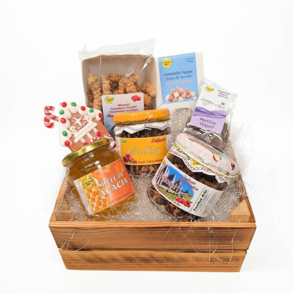 Eleganti cesti regalo natalizi artigianali con prodotti tipici del Trentino, confezionati con cura su sfondo bianco con ombre naturali. Ogni confezione è personalizzabile e include miele di acacia, biscotti, infusi selezionabili, caramelle e accessori natalizi unici. Perfetti per regali di Natale originali e raffinati.